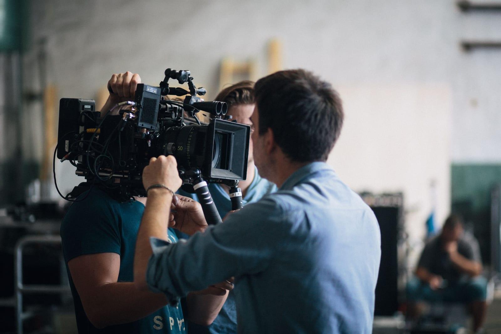 Two crew members operating a cinema camera rig on a film set